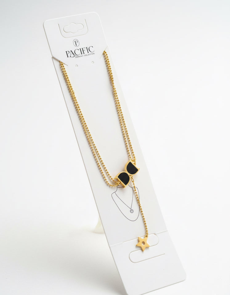 Gold necklace with black bow pendant on a white Pacific branded card